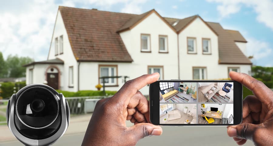 Man holding smartphone and looking at streams from video cameras